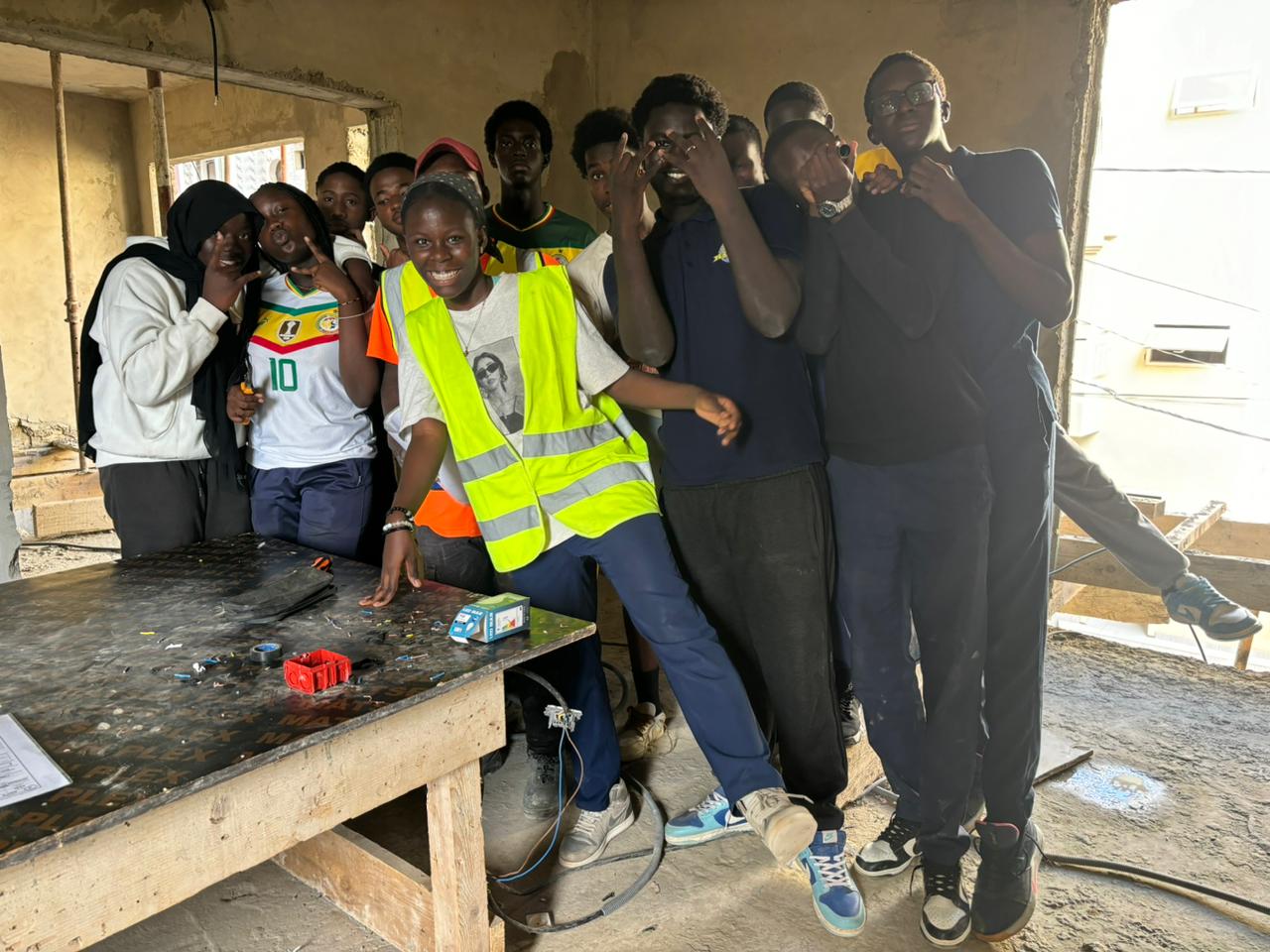 Élèves de l'ESIEX en atelier pratique d'électricité sur un chantier, avec gilets de sécurité